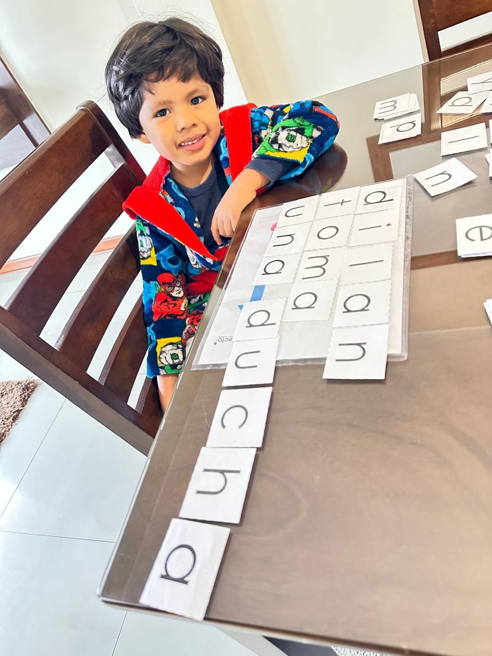 Niño practicando lectura con tarjetas de letras