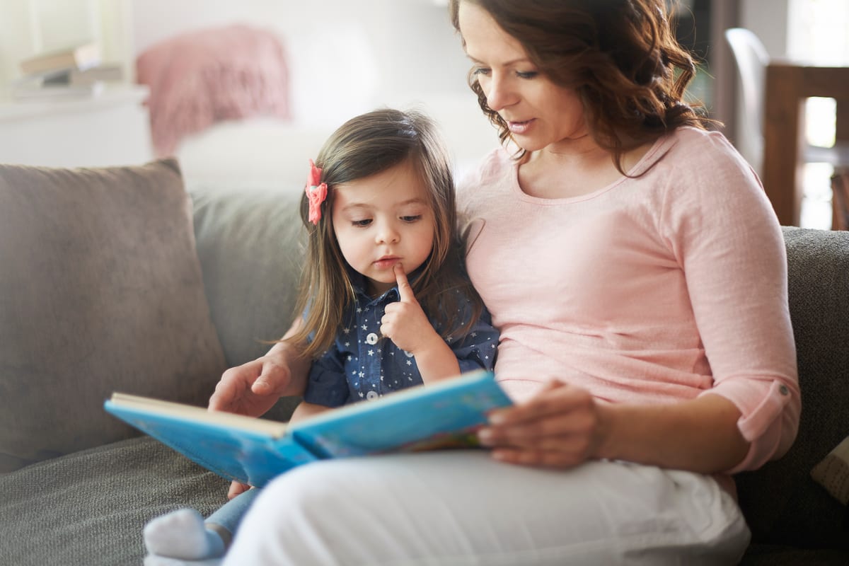 Mamá acompañando a su hijo mientras aprende a leer